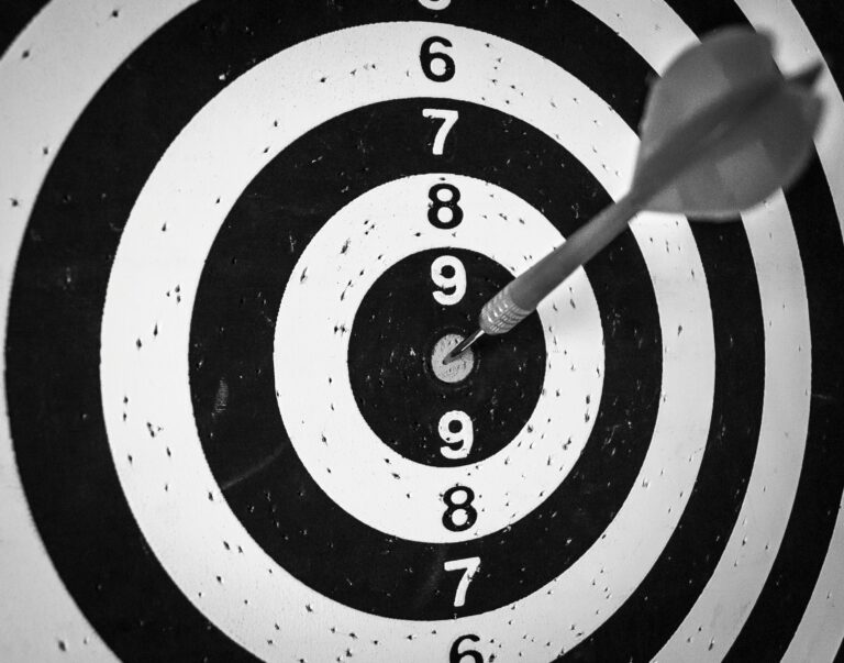 Black and white image of a dart board, with the dart on the bullseye. Photo by Mauro Gigli on Unsplash