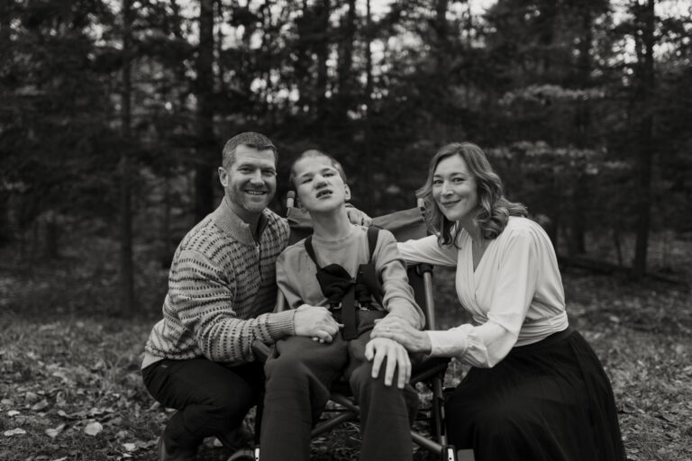 Jess, Ryan, and Lucas on the lawn, in black and white. The couple is smiling while Lucas leans against Ryan's shoulder.