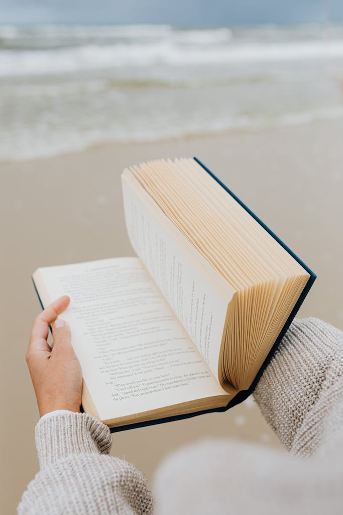 A serene moment of reading a book by the seaside, capturing relaxation and tranquility.