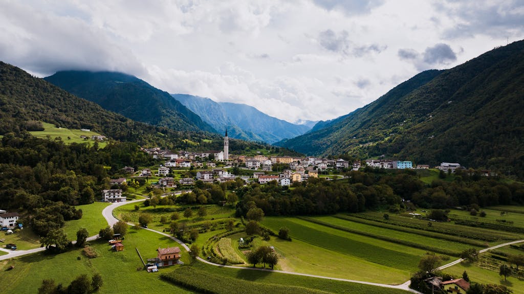 Charming aerial view of Seren del Grappa, a quaint Italian town nestled between lush green mountains.